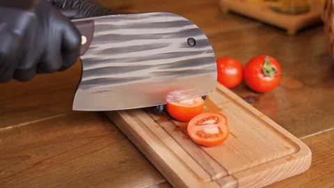 The chef slices tomatoes, demonstrating culinary skill. Place fresh tomato Stock-Footage 278032515