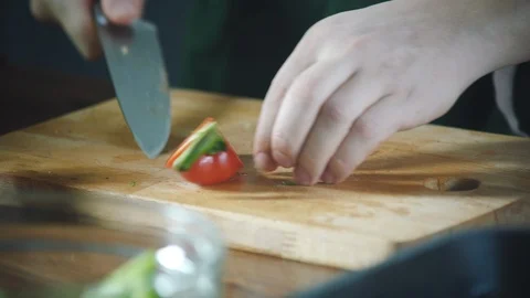 Chef slices vegetables on a cutting board in a restaurant. 스톡 동영상 124749906