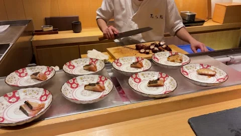 Chef slicing boiled octopus tentacle on wooden board. Video stock 334578275