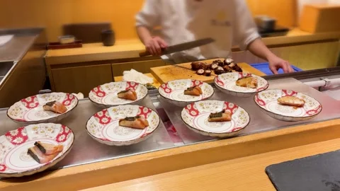 Chef slicing boiled octopus tentacle on wooden board. 스톡 동영상 335461201