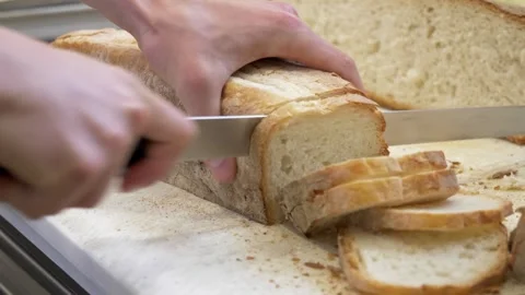Chef slicing bread for bruschetta preparation in restaurant kitchen Stock Footage 336793347