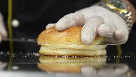 Chef slicing burger bun with gloves on 库存影片 293109796