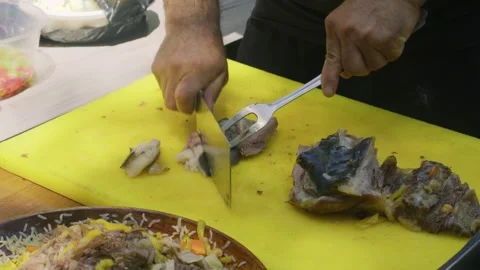 Chef slicing cooked meat for Uzbek plov beside plate of finished pilaf Stock Footage 346745357