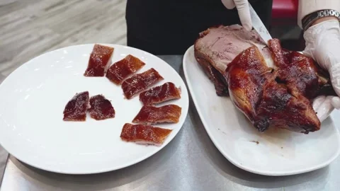 Chef Slicing Crispy Peking Duck in a Professional Kitchen Stock Footage 336230469