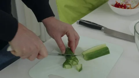 Chef slicing cucumber on cutting board Video stock 312659245