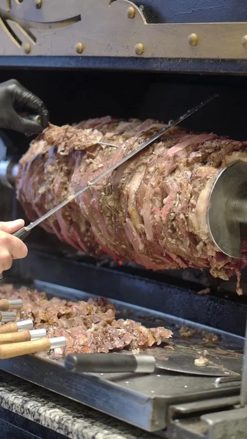 Chef Slicing Delicious Doner Kebab Meat from a Rotating Vertical Spit Stock Footage 337058031