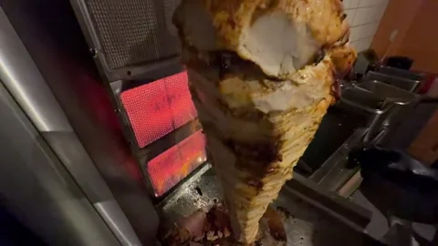 Chef slicing doner kebab meat at restaurant Видео 336232910