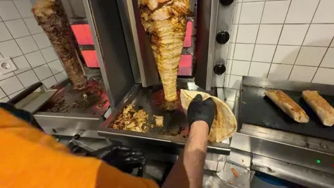 Chef slicing doner kebab meat at restaurant Vídeo Stock 336232923