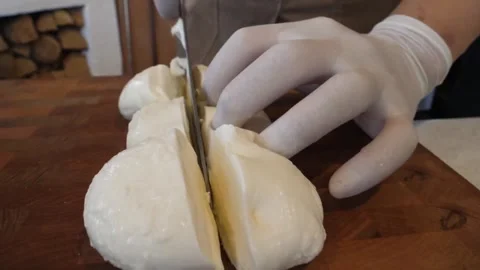 Chef Slicing Fresh Buffalo Mozzarella Cheese on Rustic Wooden Board Video stock 337677062