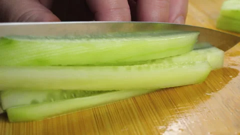 A chef is slicing a fresh green cucumber 库存影片 341557191