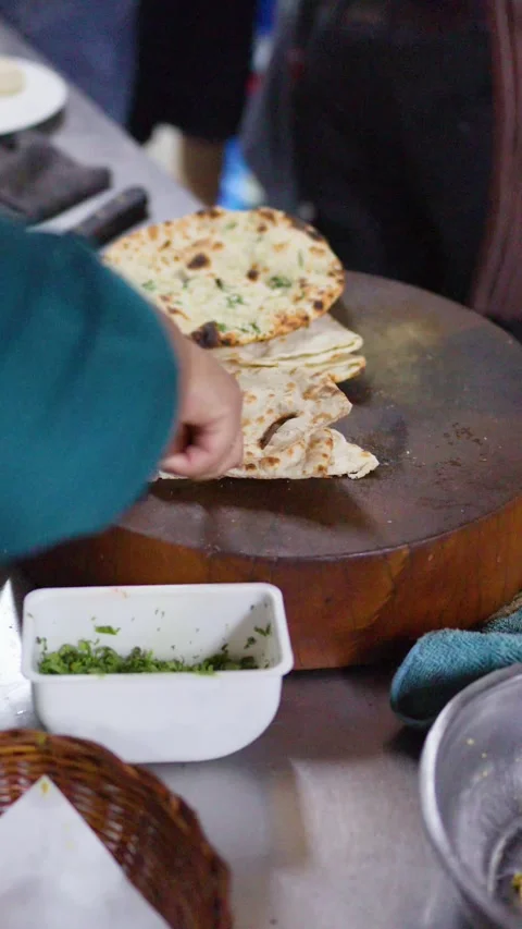 Chef Slicing Fresh Naan Bread on Wooden Board in Kitchen Stock Footage 337226286