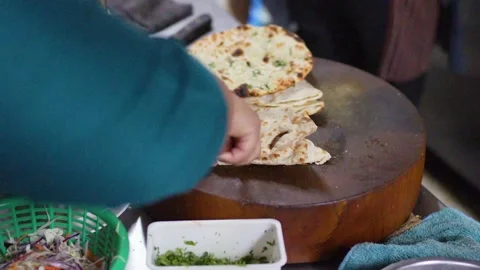 Chef Slicing Fresh Naan Bread on Wooden Board in Kitchen Stock Footage 337519962