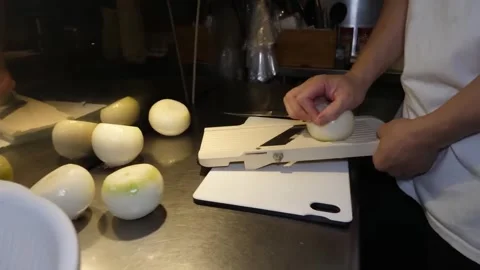 Chef Slicing Fresh Onion Thinly on a Japanese Mandoline Slicer Stock-Footage 347689401