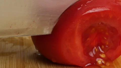 Chef slicing fresh ripe red and yellow tomatoes on a wooden cutting board. Video stock 342279970