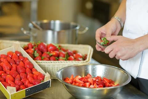 Chef Slicing Fresh Strawberries in Kitchen Bowl for Dessert Preparation Clo.. Stock Photos