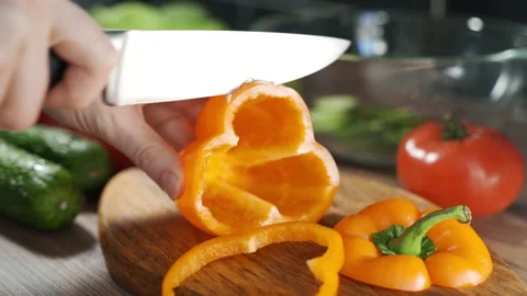 Chef slicing fresh vegetables in the kitchen. Man hand cutting orange, big Stock Footage 149748119