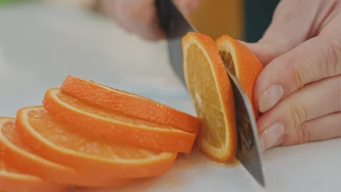 Chef slicing fruit precisely. Juicy orange segments and textured peel. Chef Stock Footage 332284414