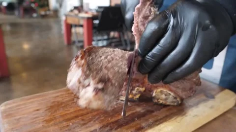 Chef Slicing Grilled Medium-Rare Beef Steak on Wooden Board Stock Footage 338211001