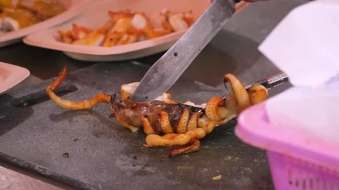 Chef Slicing Grilled Squid Tentacles on a Cutting Board Stock Footage 344218576