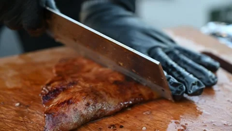 Chef Slicing a Large Roasted Pork Cut into Strips During Food Preparation Stock Footage 341155518