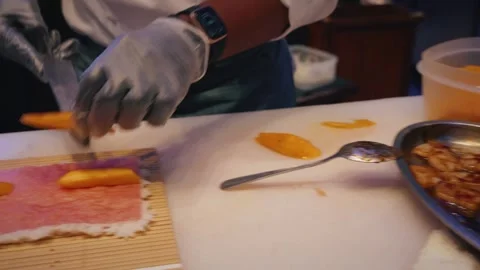 Chef slicing mango and preparing tuna rice sheet sushi rolls – 4K video Stock Footage 315565042