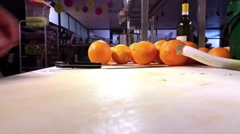 Chef is slicing oranges into small half moon slices, at a restaurant kitchen Stock Footage 58112400