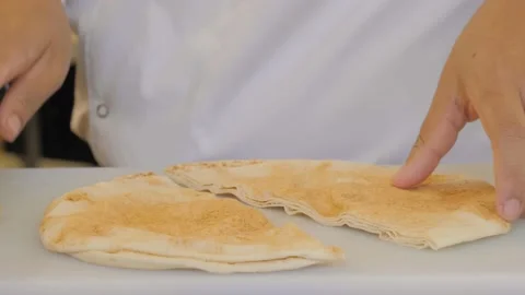 Chef slicing pita close-up. Preparing traditional Turkish bread for holy month 스톡 동영상 172556702
