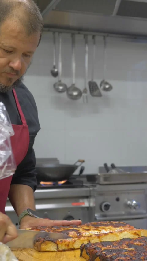 Chef slicing pizza before serving guests at celebration Stock Footage 340151920