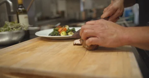 Chef Slicing Pork in Professional Kitchen, Slow Motion Video stock 127526064