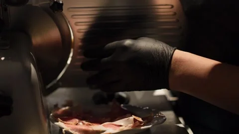 Chef Slicing Prosciutto Ham with Professional Meat Slicer Machine Stock Footage 340245284