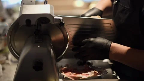 Chef Slicing Prosciutto Ham with Professional Meat Slicer Machine Stock Footage 340322147