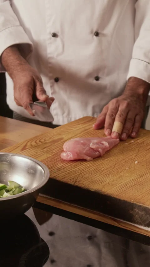 Chef Slicing Raw Chicken Breast During Cooking Master Class in Restaurant Stock Footage 332650513