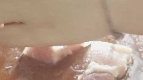 A chef slicing raw pork belly with a sharp knife on a wooden cutting board i Video stock 337618811