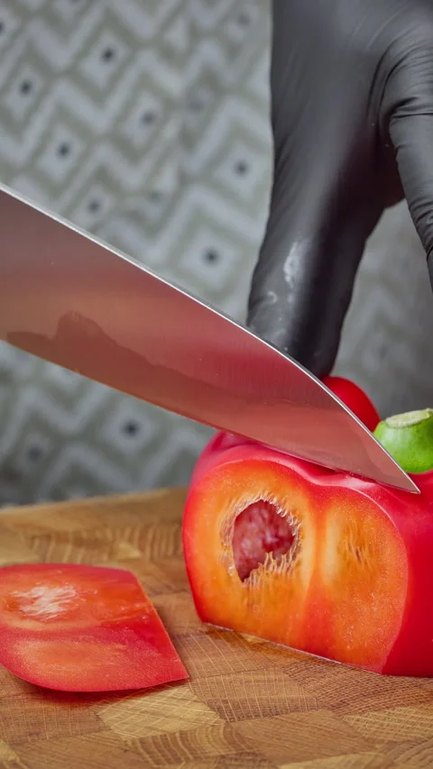 Chef slicing red pepper carefully. Detailed view of food preparation Video stock 329277104