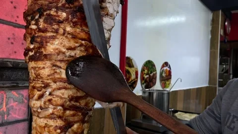 Chef Slicing Roasted Chicken Shawarma Meat from Vertical Grill Rotisserie Stock Footage 238979806