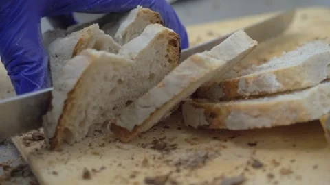 Chef slicing rustic homemade bread for appetizer buffet Stock Footage 340152257