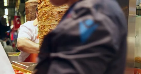 Chef slicing shawarma meat from vertical rotisserie spit Stock Footage 339631296