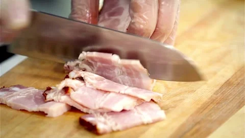Chef slicing smoked bacon block on a wooden board Video stock 333830983