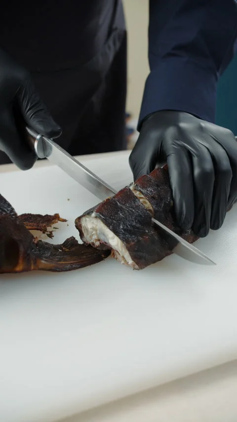 Chef slicing smoked fish on cutting board Stock Footage 307861451