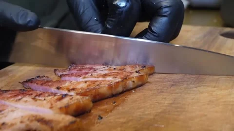 Chef slicing thick-cut grilled pork belly on a wooden cutting board 스톡 동영상 332815006