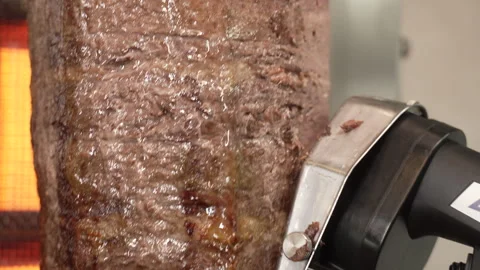 Chef slicing thin layers of roasted meat  for a traditional doner kebab Stock Footage 335382428
