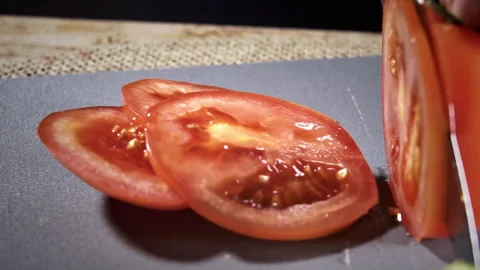 A chef is slicing a tomato with a kitchen knife. Stock Footage 297605289