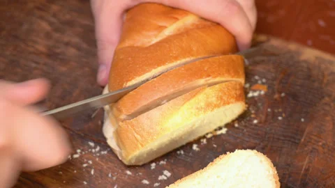Chef slicing Whole grain bread close-up on the wooden cutting board. Stock Footage 254076903