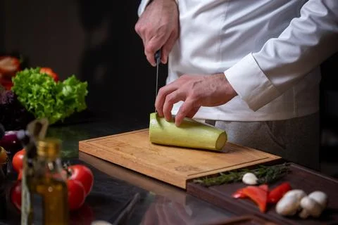 Chef Slicing Zucchini in Kitchen Stock Photos