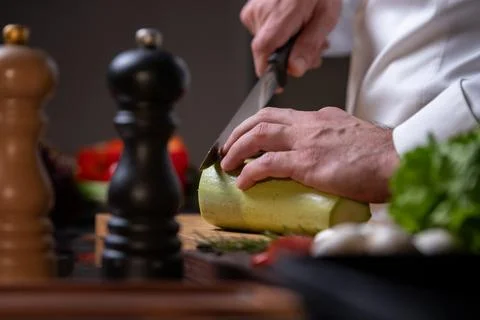 Chef Slicing Zucchini in Kitchen Stock Photos