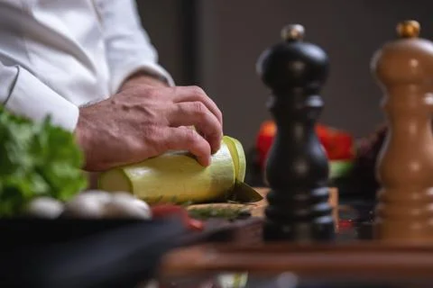 Chef Slicing Zucchini in Kitchen Stock Photos