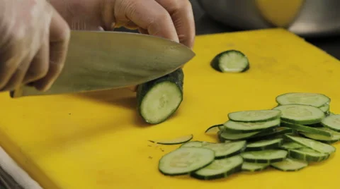 Chef slowly slicing a cucumber, close up Stock-Footage 66065183
