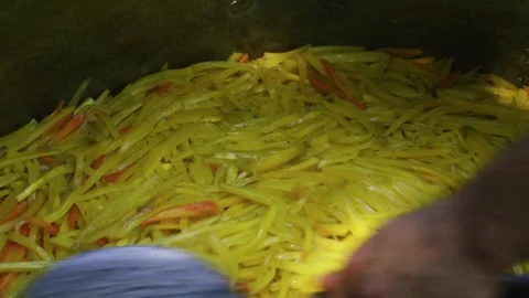 Chef Smoothing Sliced Carrots in Large Metal Cauldron for Plov, Close Up Stock Footage 332762491