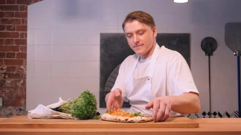 Chef sniffs pizza decorated with herbs and shows thumb up Stock Footage 133359722