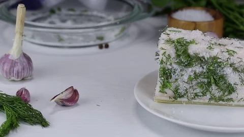The chef soaks in salt, garlic and chopped dill a large piece of pork fat Stock Footage 121784442